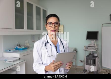 Serious senior ultrasound diagnosis doctor woman posing in work office Stock Photo