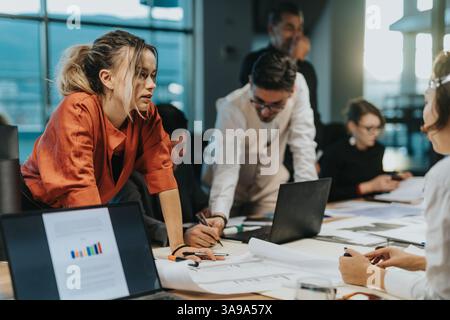 Multiracial colleagues brainstorm ideas for a new project in a contemporary office setting, showcasing teamwork and creativity. Stock Photo