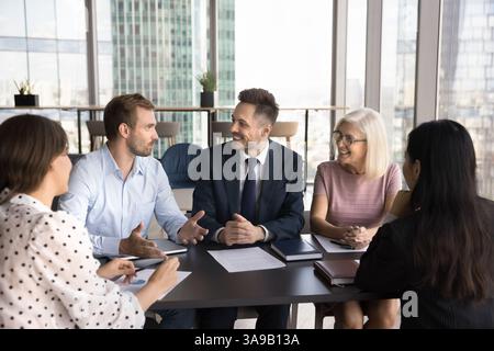 Colleagues talking during morning briefing in modern conference room Stock Photo