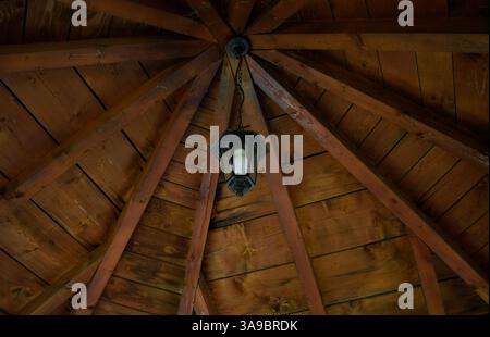 An ornate hanging lighting under the wooden roof. Stock Photo