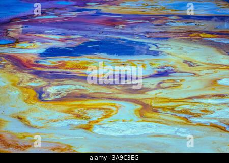 Taken in Yellowstone National Park in 2018, this is a closeup abstract photo of one of the many swirling colorful lave pools in the park. Stock Photo