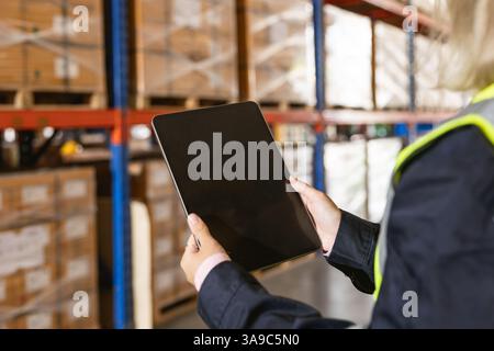 closeup warehouse worker using modern tablet computer wireless digital software application technology device in logistic cargo management Stock Photo