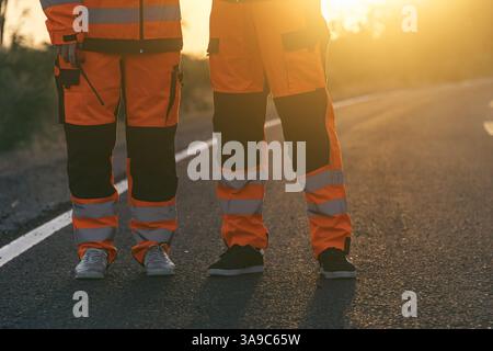 Engineer worker wearing safety suite walking survey inspect at new construction street road highway for final build quality check in sunset Stock Photo