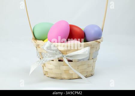 A basket with colorful easter eggs on white background, side view Stock Photo
