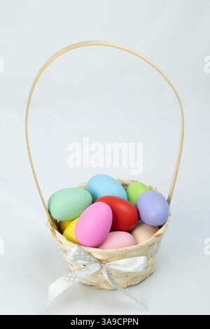 Easter eggs in a basket on a white background, horizontal high-angle view Stock Photo