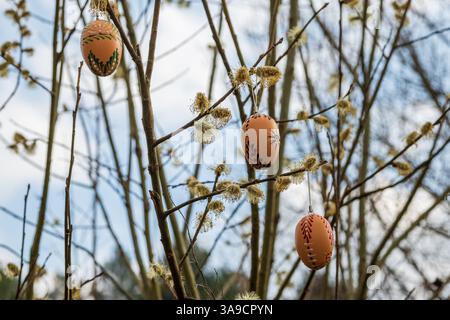 Three Traditional Wax-Painted Easter Eggs Hanging on Willow Branches, horizontal Stock Photo