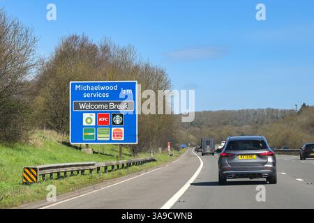 Gloucestershire, England, UK - 29 March 2025: Traffic on the M5 motorway passing a sign showing drivers the distance to the Michaelwood services Stock Photo
