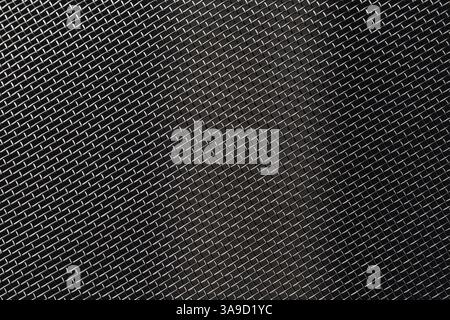Fine metal mesh on a dark background, laid diagonally and side-lit. Stock Photo