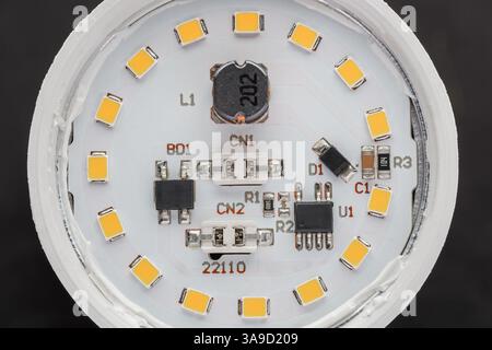 The internal structure of a disassembled LED lamp. The board with electronic components close-up. Macro photography Stock Photo