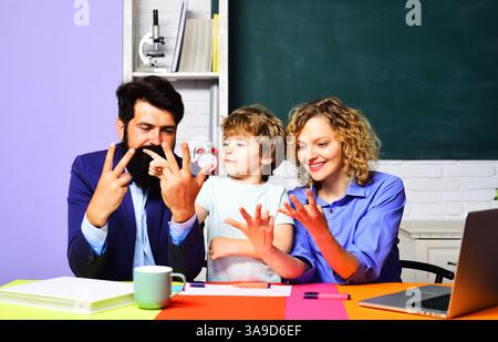 Schoolboy student doing math homework with tutors and learning to count on fingers. Mathematics for children in school. Child boy in classroom study m Stock Photo