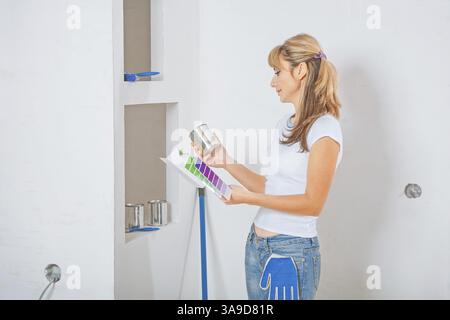 Female painter holding and looking on color palette with paint Stock Photo