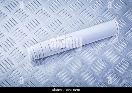 Rolled up blueprints on grooved metal sheet top view construction concept Stock Photo