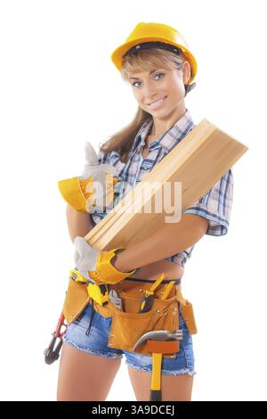 Portrait of young female construction worker carrying wooden boards on arm against white background Stock Photo