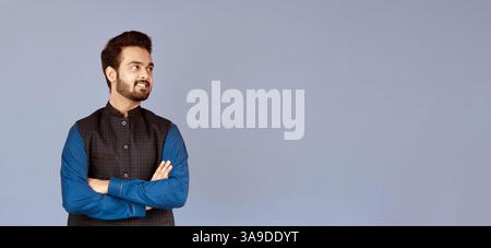 Positive Indian guy standing with crossed arms on lilac background ...