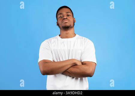 Cool Black Man Standing Crossing Hands Posing On Blue Background Stock Photo