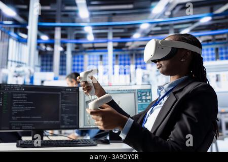 Solar panels plant worker analyzing performance data, optimizing efficiency using VR equipment. Woman in photovoltaics factory engineer works on solar cells design prototype using virtual reality gear Stock Photo
