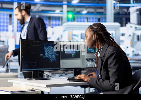 Photovoltaics factory developer programming AI tools, developing solutions to automate fault detection. Specialist using machine learning to analyze data and predict potential equipment failures Stock Photo