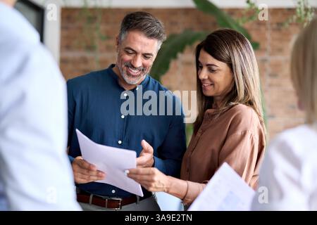 Corporate leaders discussing financial documents standing in office. Stock Photo