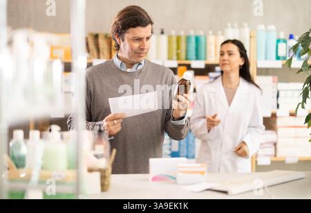Man buyer scans syrup qr code with woman pharmacist Stock Photo