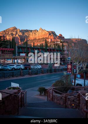 Holiday lights and Christmas decorations in Uptown Sedona, Arizona, with red rock cliffs at sunset creating a festive Southwest atmosphere. Stock Photo