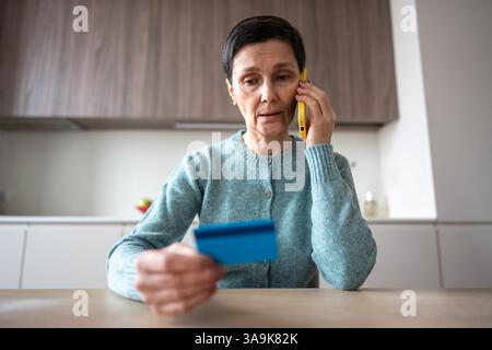 Scared confused naive woman transferring money accounts scammers phone fraud financial manipulation Stock Photo