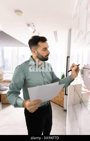 Serious Latin manager man using Kanban scrum board Stock Photo