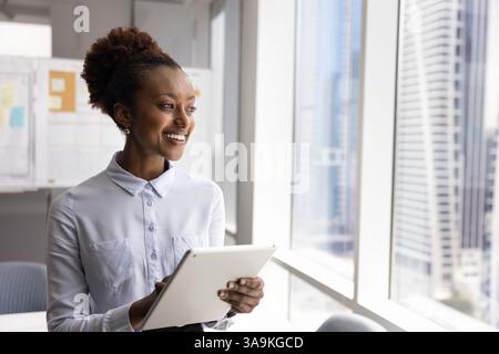 Happy young African business executive woman using digital tablet Stock Photo
