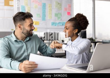 Happy project managers celebrating business success and giving fist bump Stock Photo