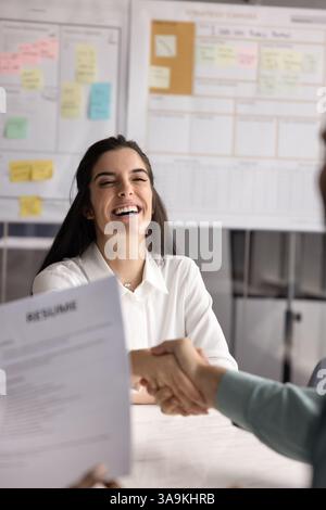 Cheerful Hispanic young applicant woman getting hired Stock Photo