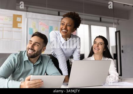 Happy multiethnic young project managers working on online project Stock Photo