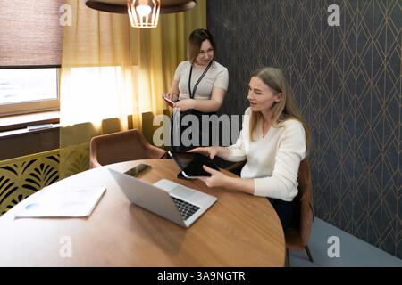 Team members collaborate in modern office space during afternoon meeting to discuss project details and plan next steps Stock Photo