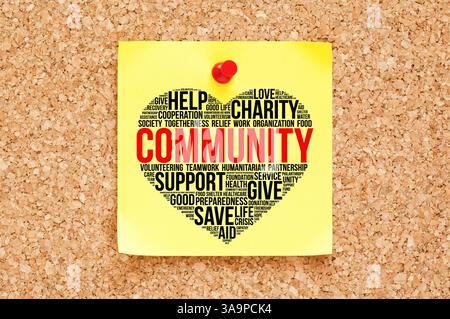 Community word cloud in a heart shape on sticky note. Concept about charity, togetherness, volunteering, humanitarian relief aid work, and empathy. Stock Photo