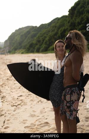Friends with surfboard standing at beach Stock Photo