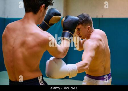 Two boxers training intensely in a gym during practice session Stock Photo