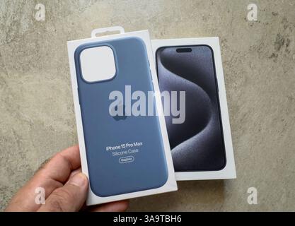 Berlin, Germany - Sep 29, 2023: An Apple iPhone 15 Pro Max silicone case in winter blue held next to the retail box of the matching iPhone showing the Stock Photo