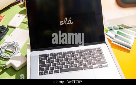 Paris, France - Mar 13, 2025: Unboxing scene of a new MacBook Air M4 edition with the screen displaying ola during setup surrounded by charger cable a Stock Photo