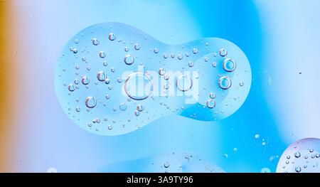 Macro photo of oil and water bubbles on blue gradient backdrop. Ideal for skincare, science, and design visuals. Stock Photo
