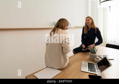 Business meeting between two women in a bright office space discussing ideas and strategies for future projects Stock Photo