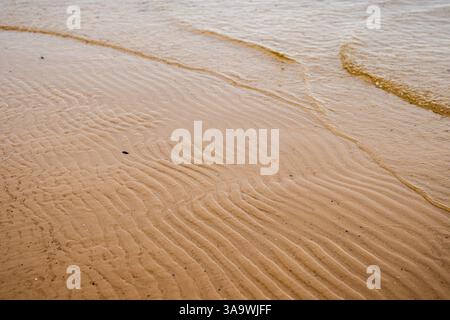 Seamless wet sand with sea water on a whole background. Empty wavy sandy sea bottom. Exotic Sandy Ocean beach surface. Top view. Simple, minimalistic Stock Photo