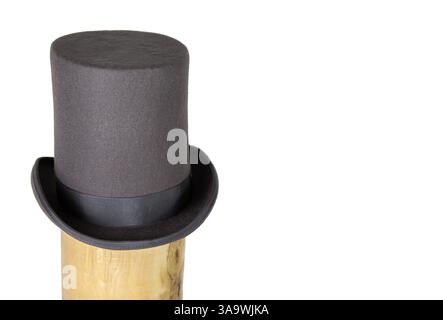 Magic hat. Topper. Elegant vintage gray beige wool felt top hat with black band on the wooden hat block. Grosgrain ribbon trim around rolled brim. Iso Stock Photo