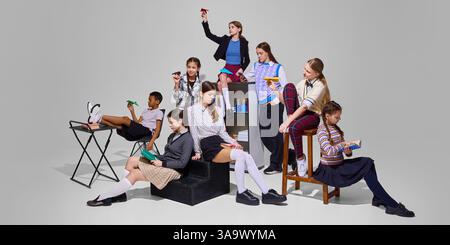 Group of students in varied poses, some with paper planes, others reading, depicts dynamic and engaging back to school atmosphere. Education concept. Stock Photo