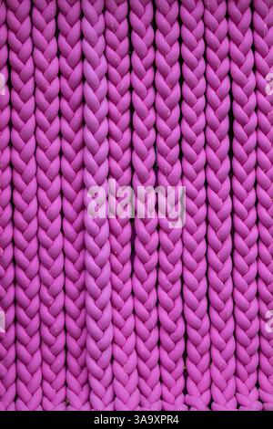 Knitted braids from pink fabric. Background Stock Photo