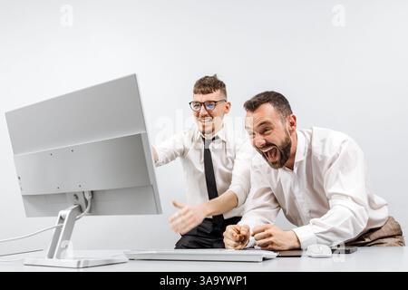 Two happy successful excited businessmen celebrating a successful stock trade, the rise of cryptocurrencies in the crypto stock market. Stock Photo