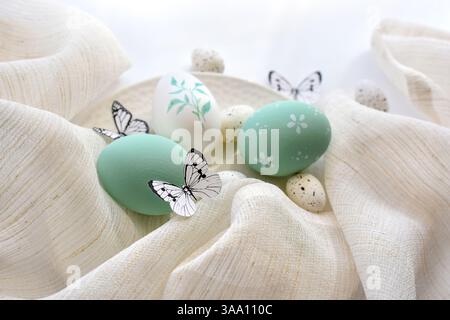 Stylish easter eggs and butterflys on linen cloth on white plate. Happy Easter concept Stock Photo