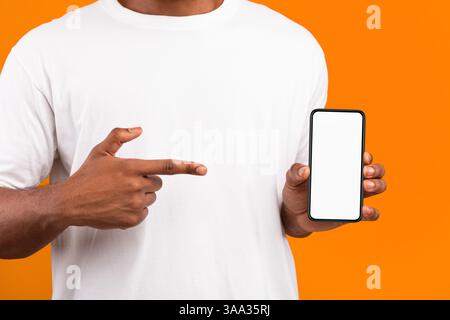 Black Man Showing Smartphone With Blank Screen, Yellow Background Stock Photo