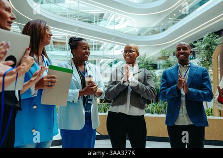 Group of diverse professionals in business attire having a discussion in a modern law firm office, showcasing teamwork and collaboration. Stock Photo