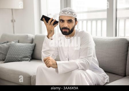 Arabic man lead talk on speakerphone, or listening received message Stock Photo