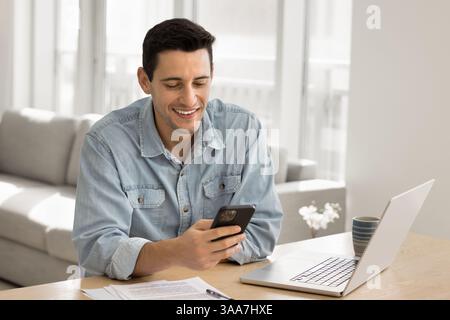 Handsome smiling man using his modern smartphone Stock Photo