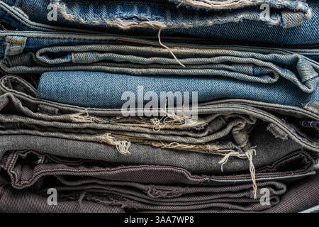 Stack of blue and gray ripped jeans. Denim background. Texture of jeans Stock Photo