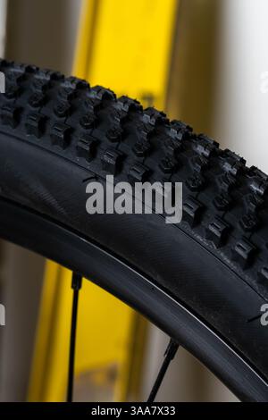 Close up bicycle tire on yellow bike rack in workshop Stock Photo